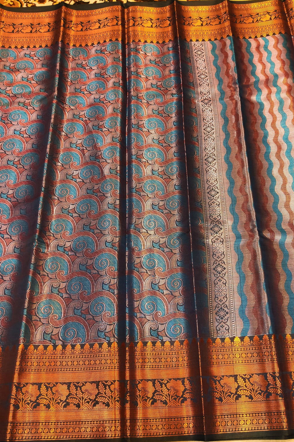 Traditional patterned fabric with blue and brown design on a plain background