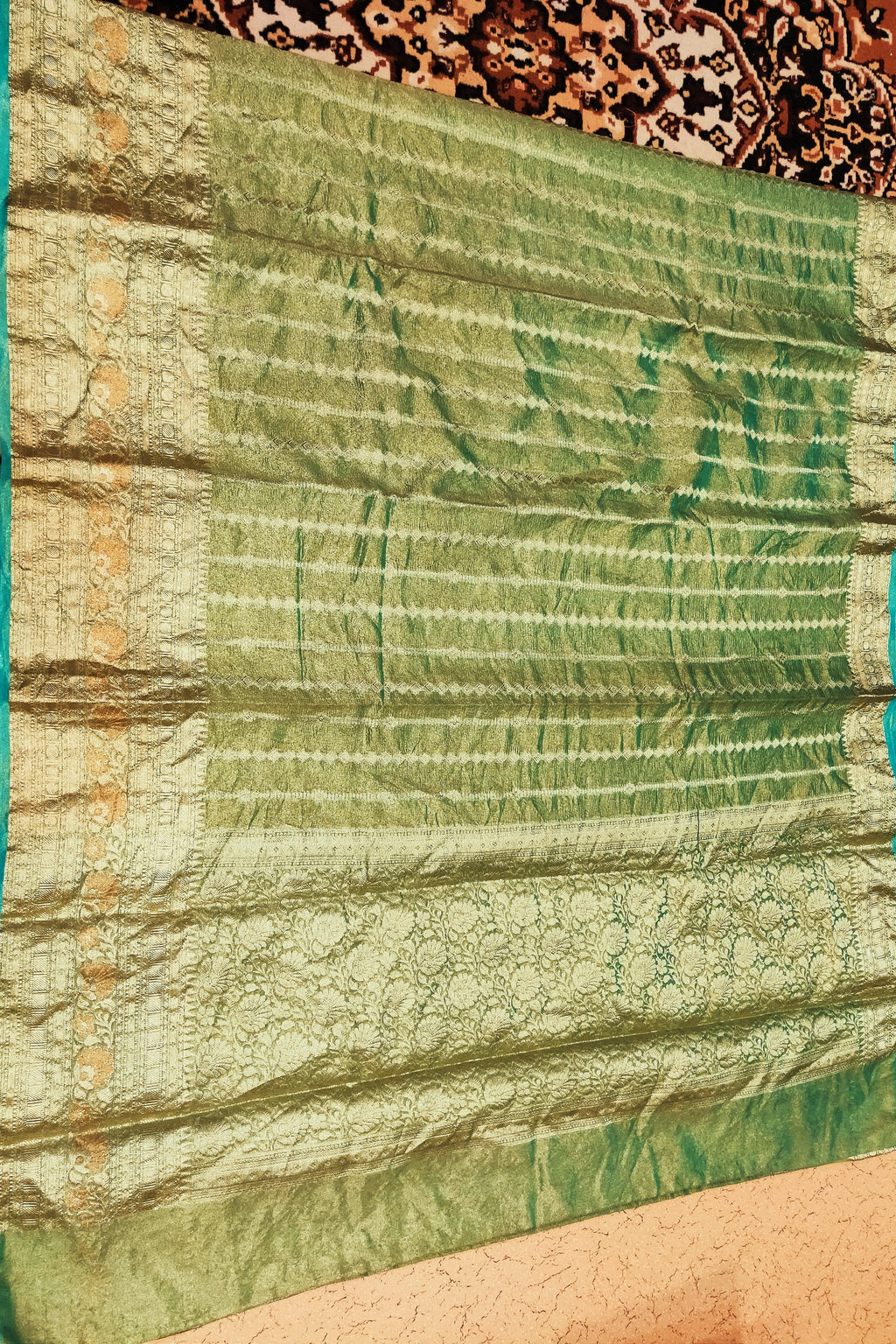 Green fabric with a textured pattern on a brown background