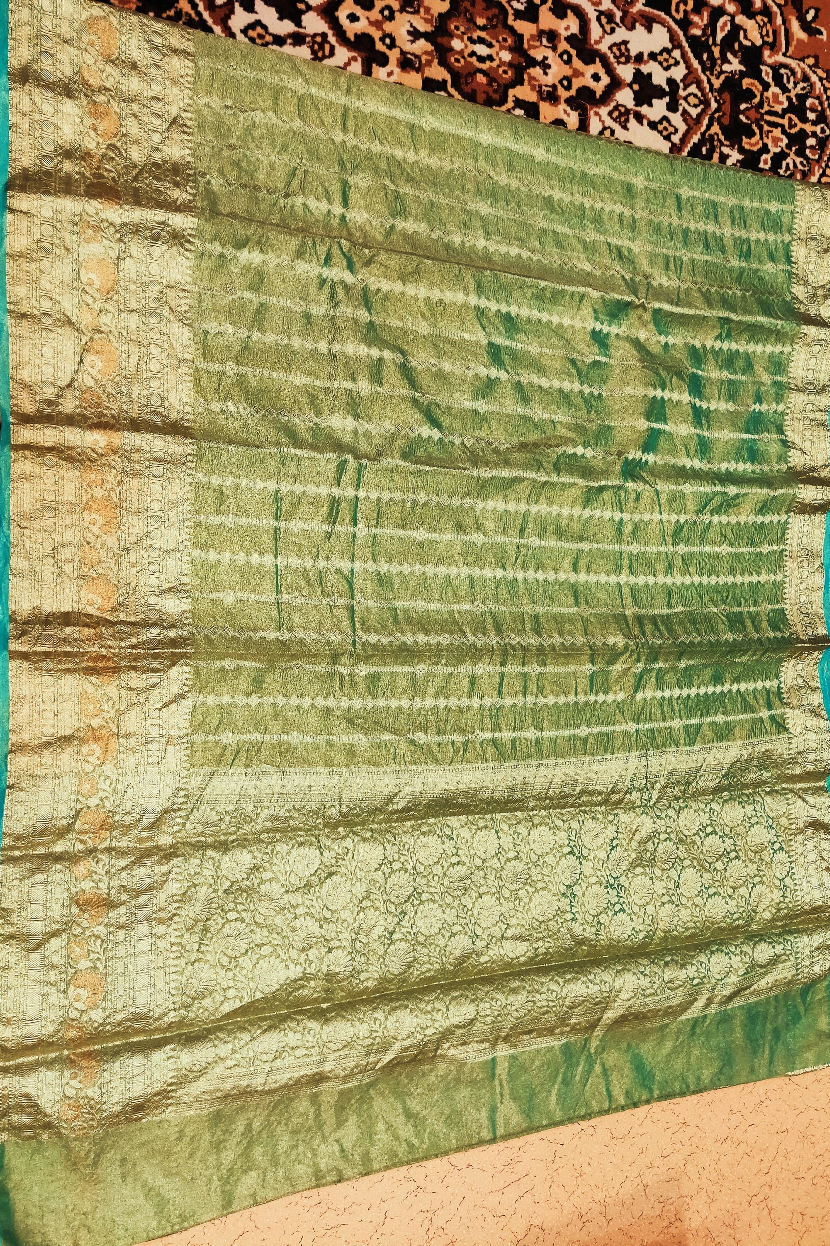Green fabric with a textured pattern on a brown background