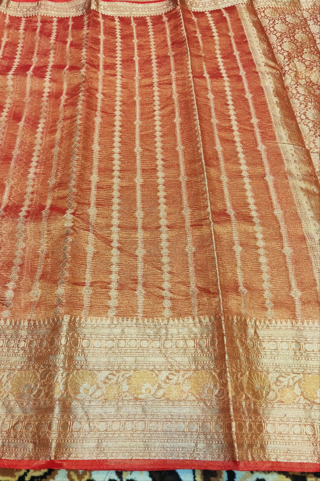 Red and gold patterned fabric with intricate designs