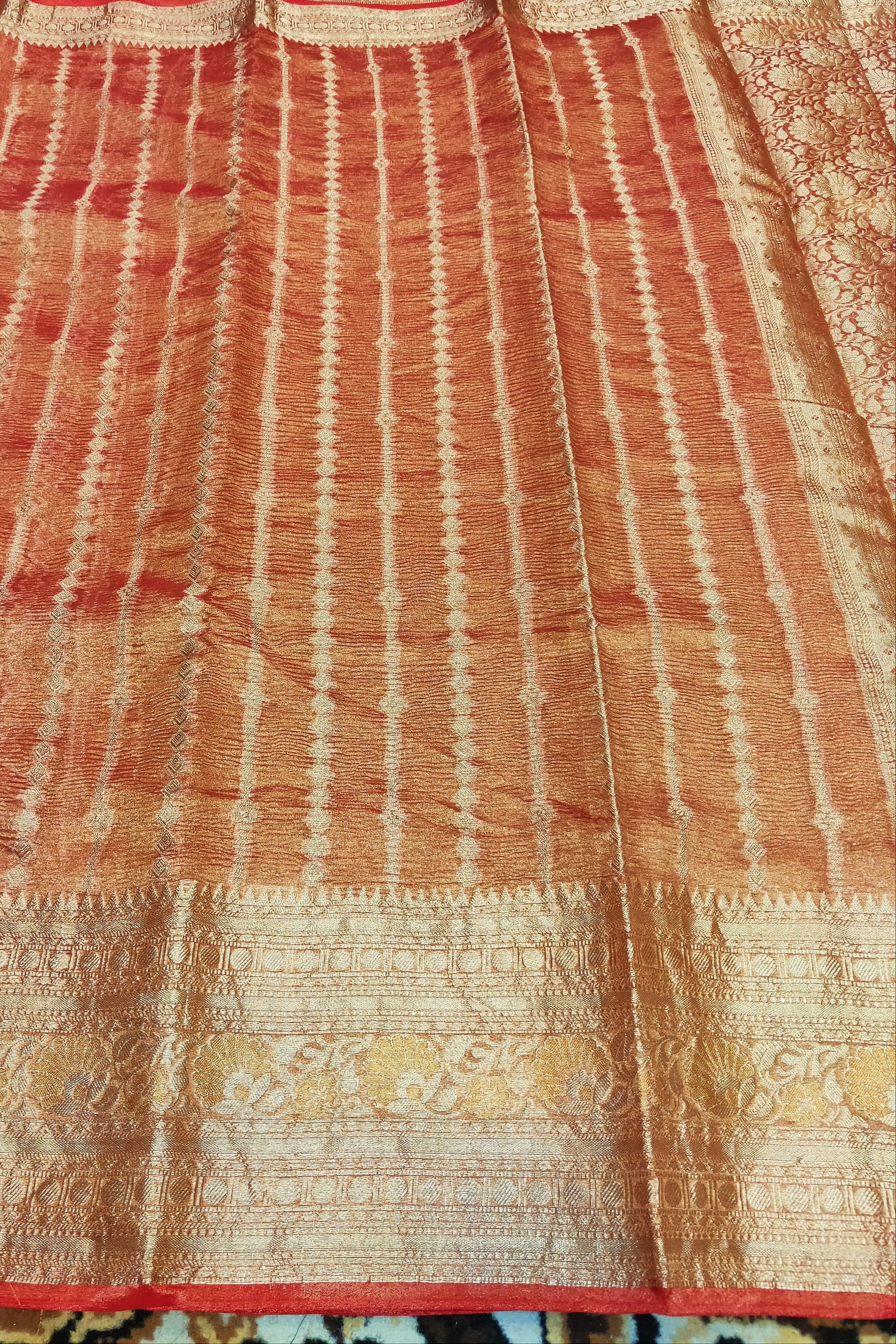 Red and gold patterned fabric with intricate designs