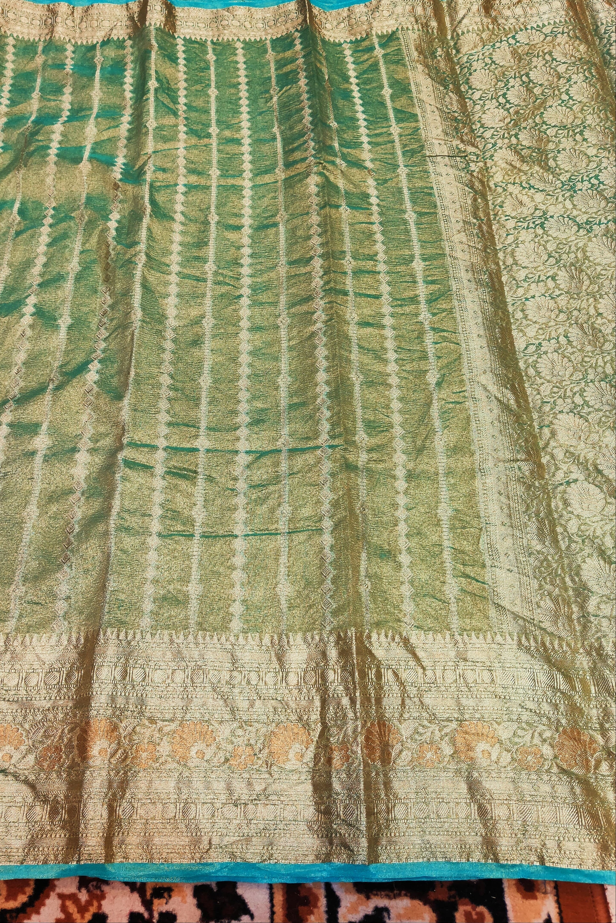 Close-up of a green and beige patterned fabric with a textured surface.