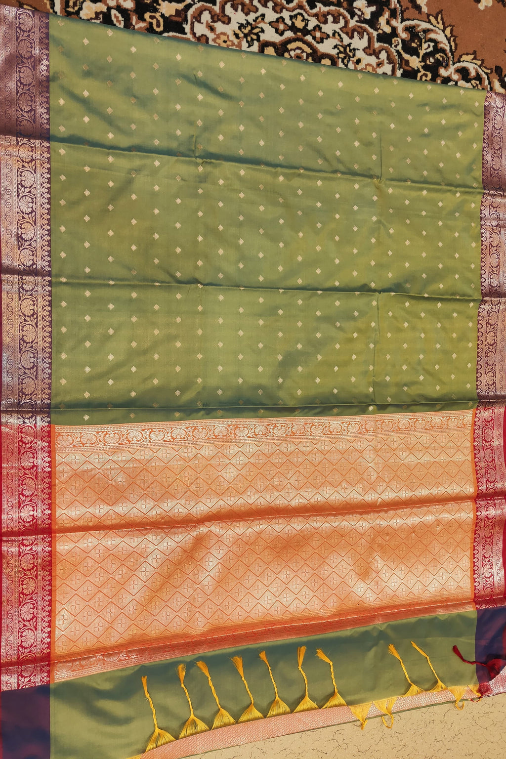 Green and orange saree with a patterned background