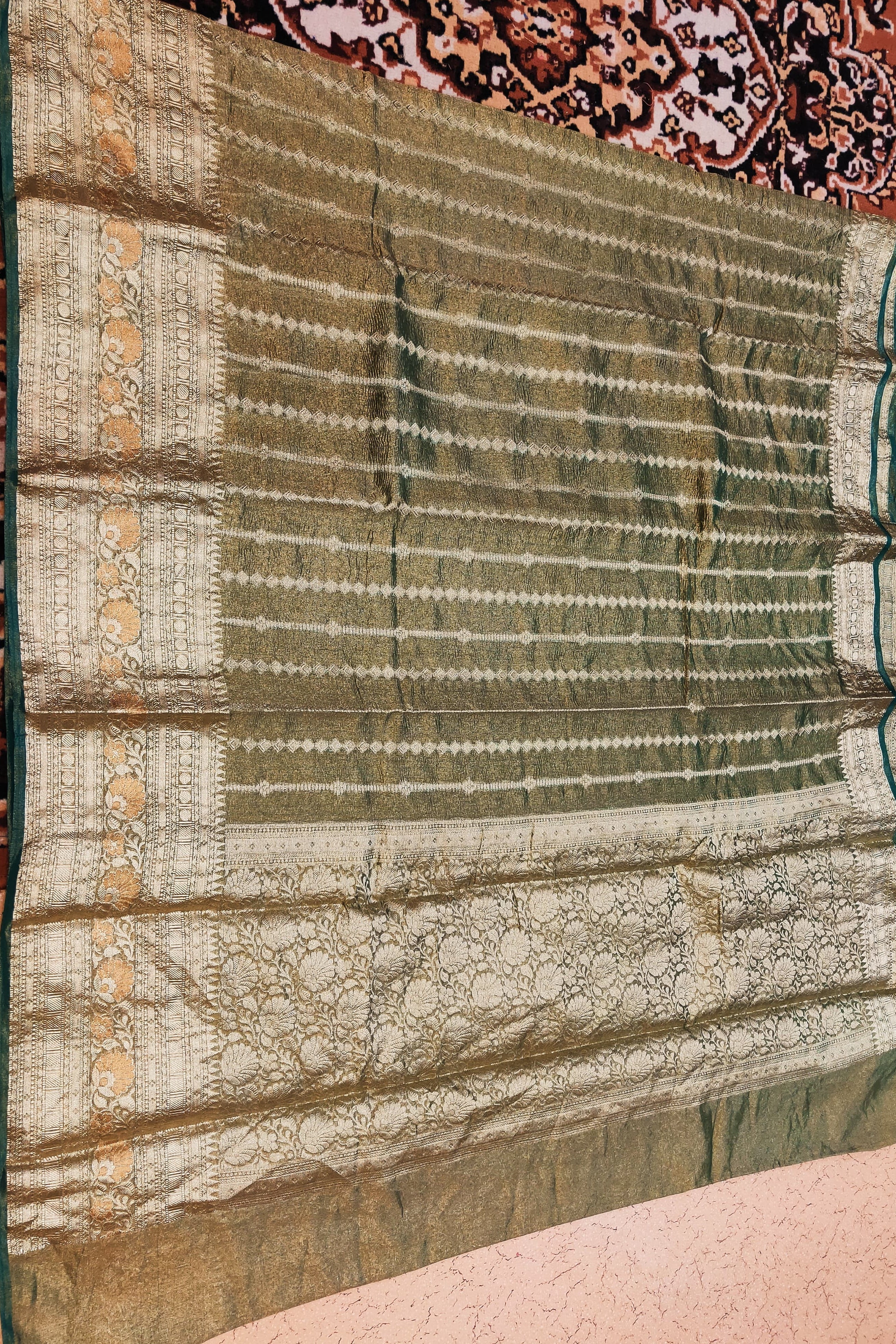 Green and white patterned fabric on a textured surface