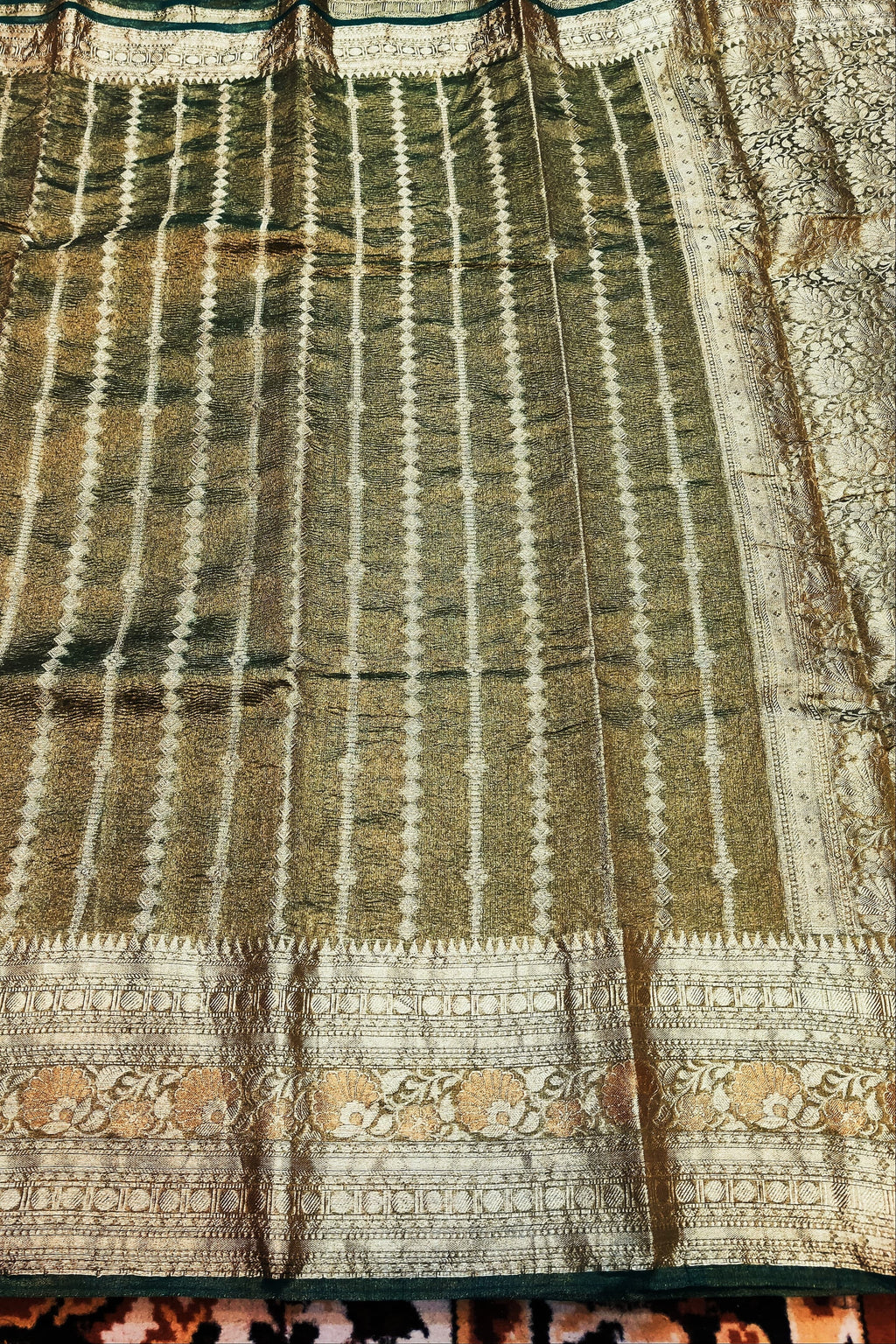 Traditional fabric with intricate patterns and colors on a textured surface