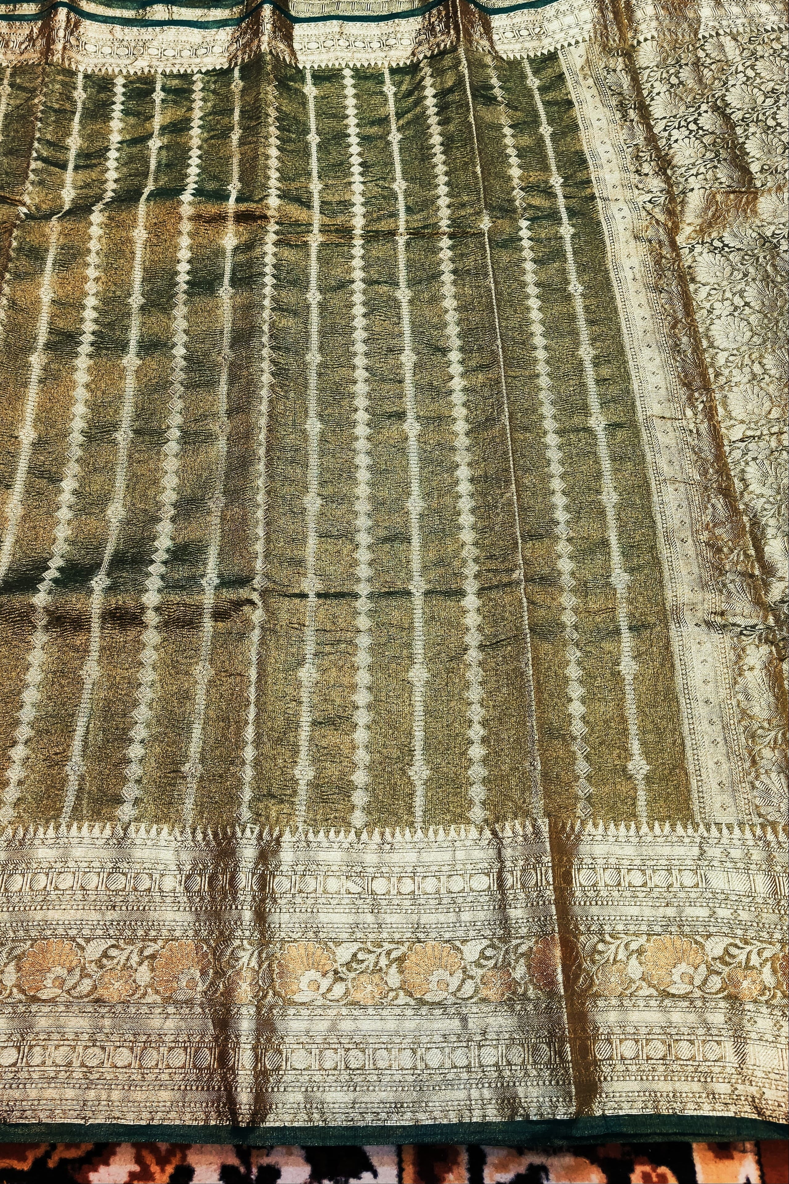 Traditional fabric with intricate patterns and colors on a textured surface