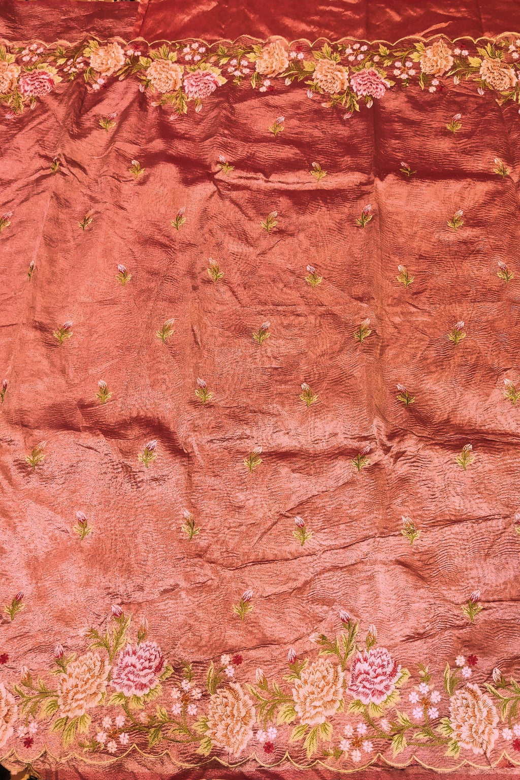 Pink fabric with floral embroidery on a patterned background