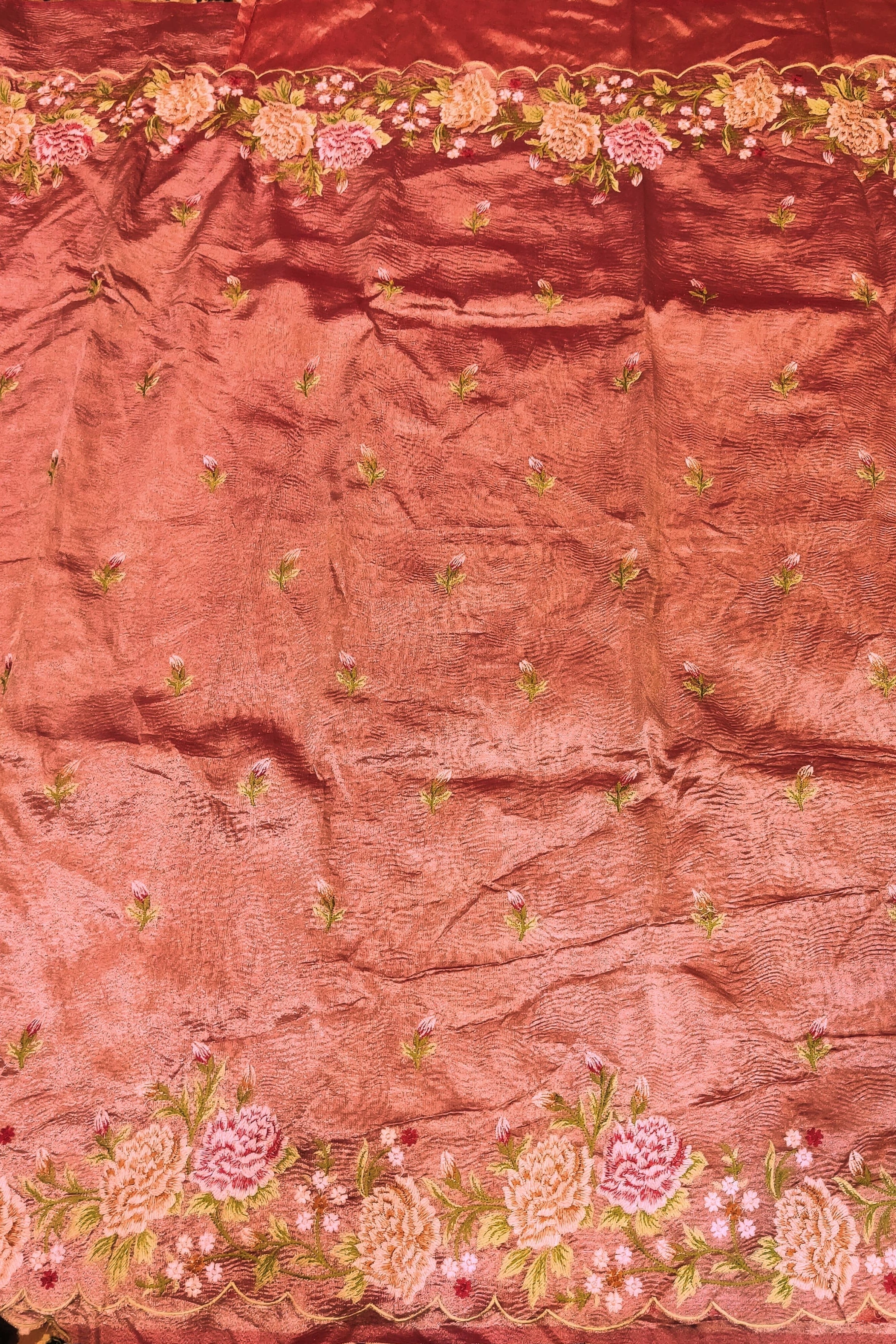Pink fabric with floral embroidery on a patterned background
