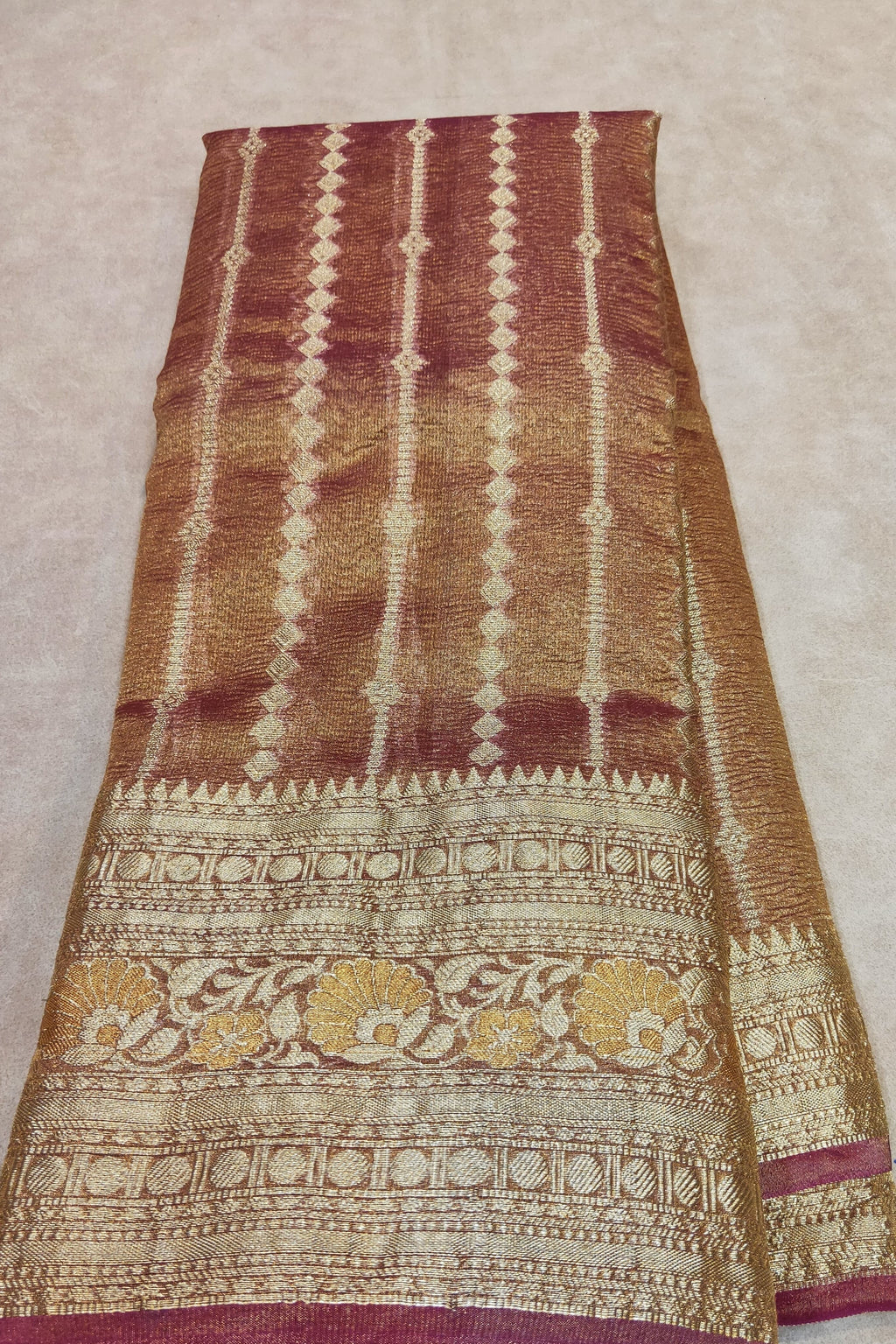 Patterned fabric held by a hand on a beige background