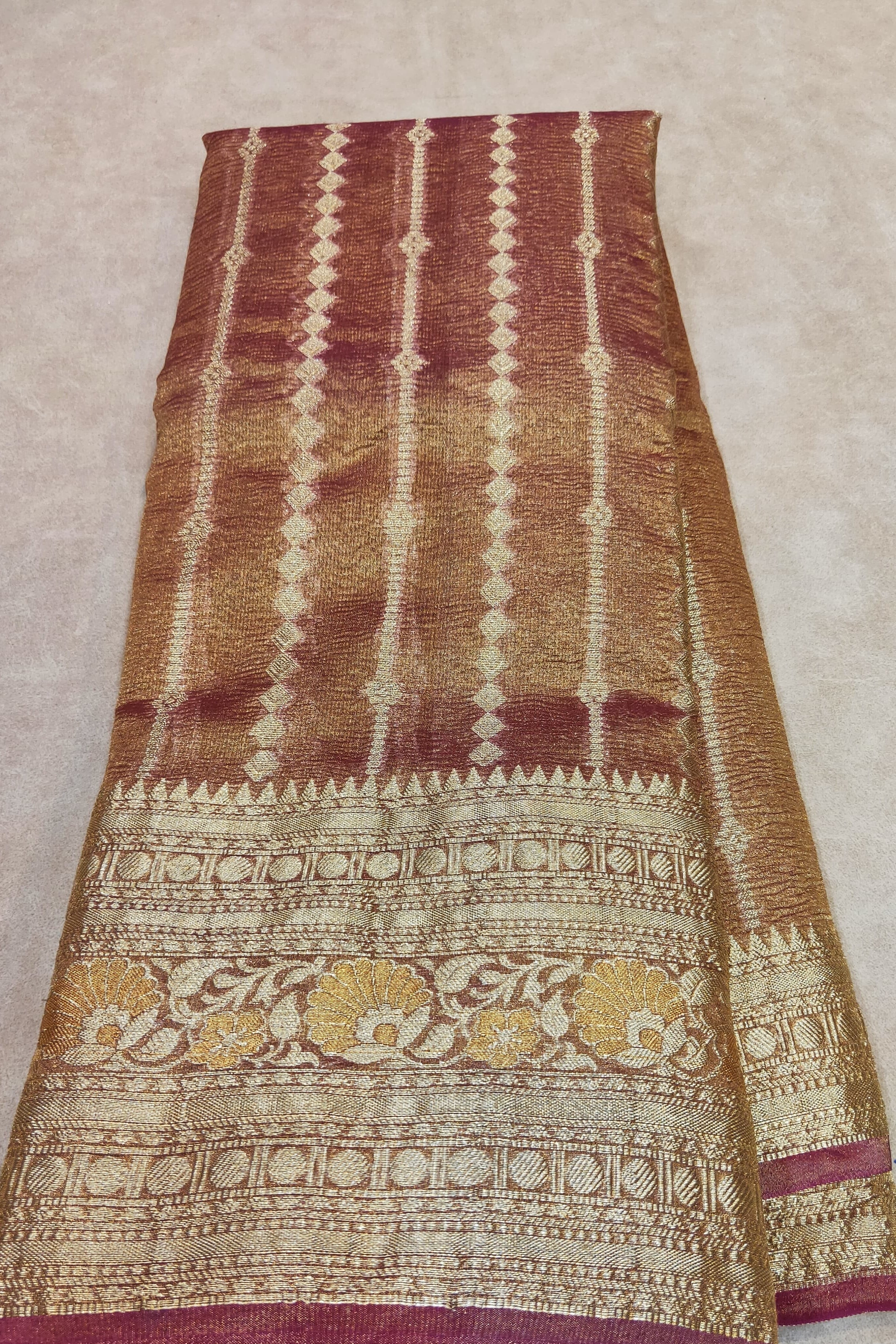 Patterned fabric held by a hand on a beige background