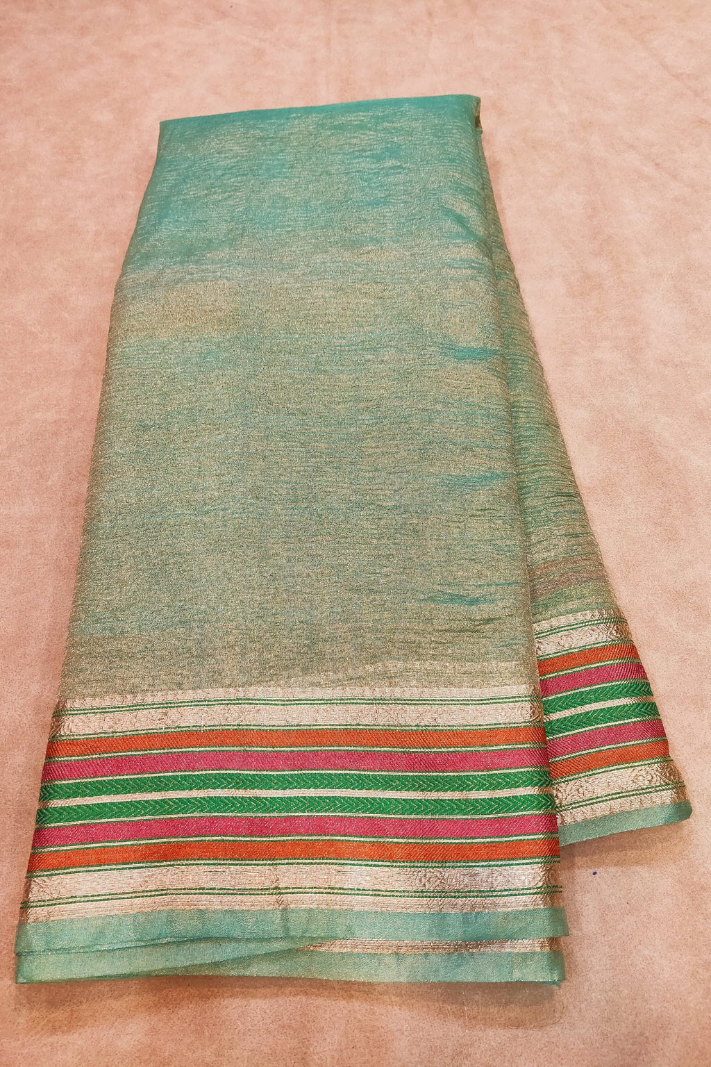 Green fabric with colorful stripes on a beige background