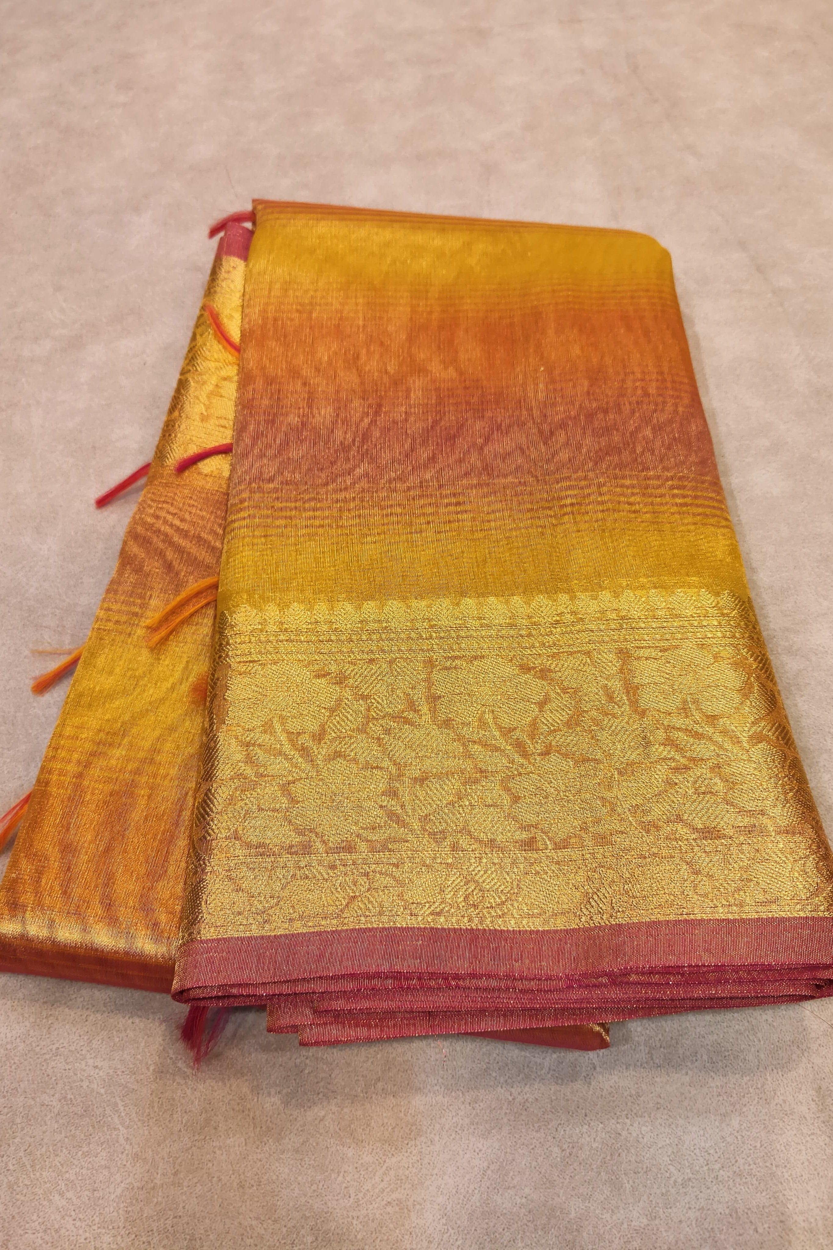 Folded fabric with gradient colors from orange to red on a beige background