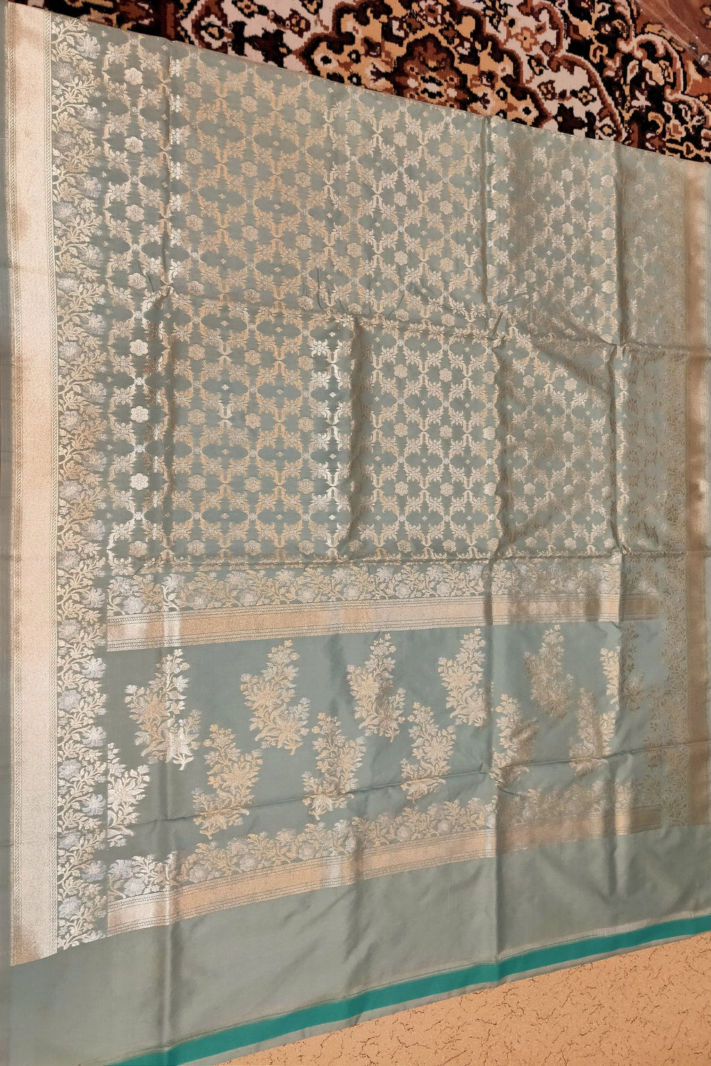 Traditional saree with intricate patterns on a textured surface