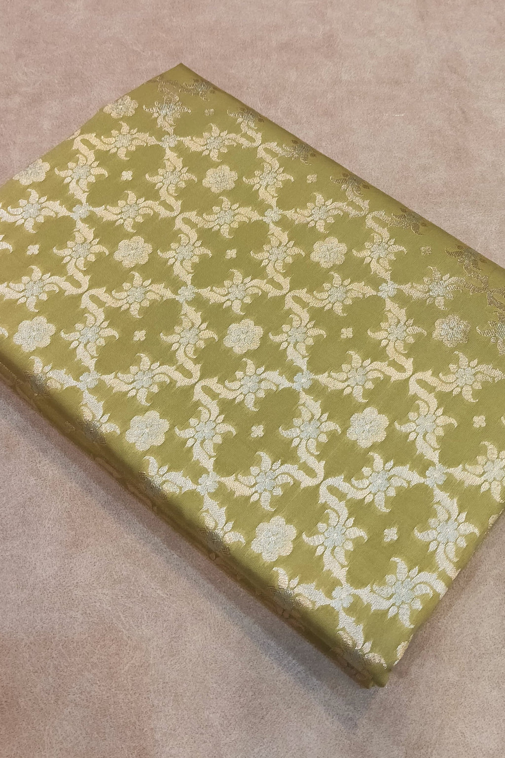 Green box with floral pattern on a beige surface