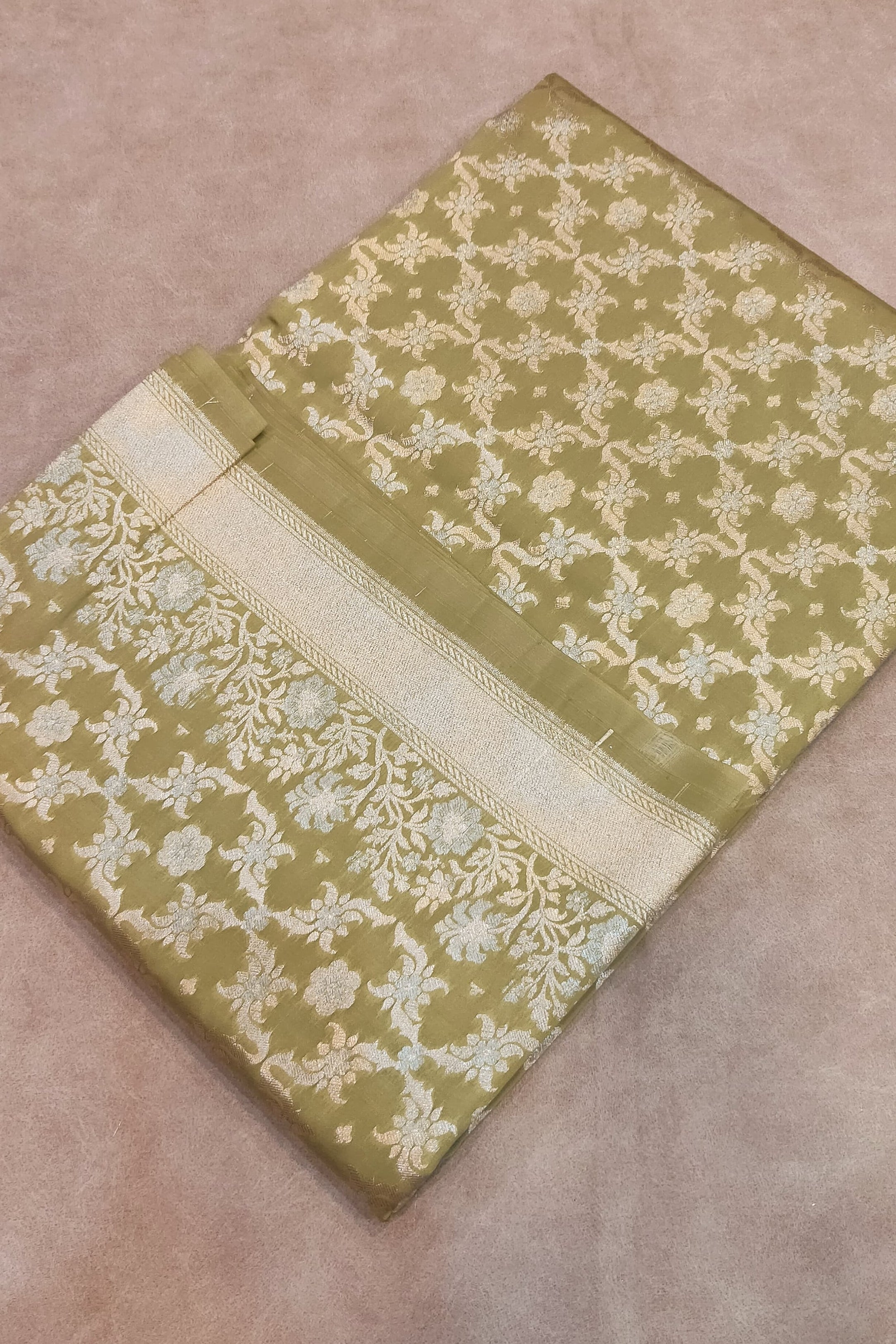 Folded fabric with intricate pattern on a beige background