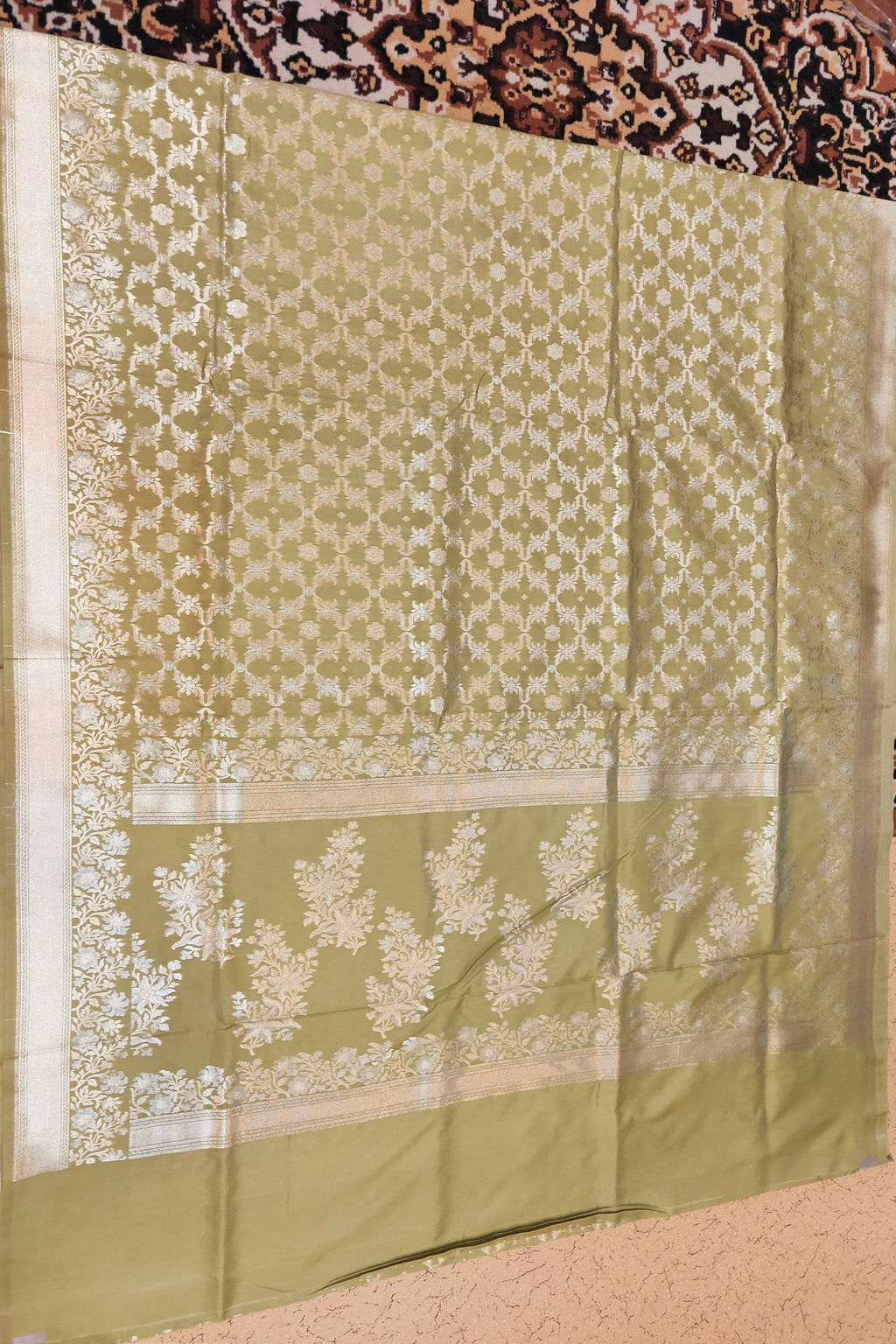 Green fabric with white floral patterns on a patterned background