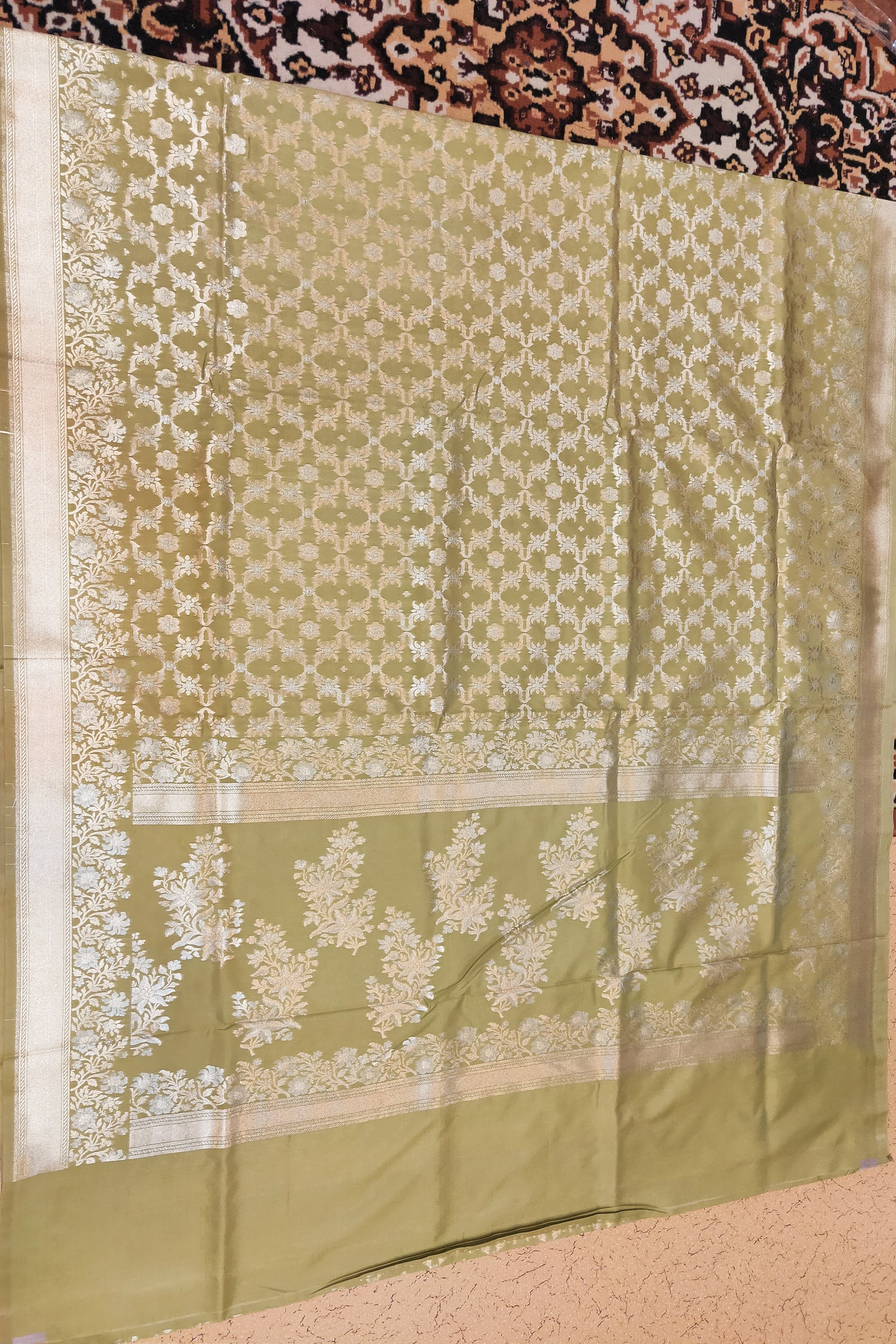 Green fabric with white floral patterns on a patterned background