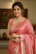 Woman in a pink saree with a blurred indoor background