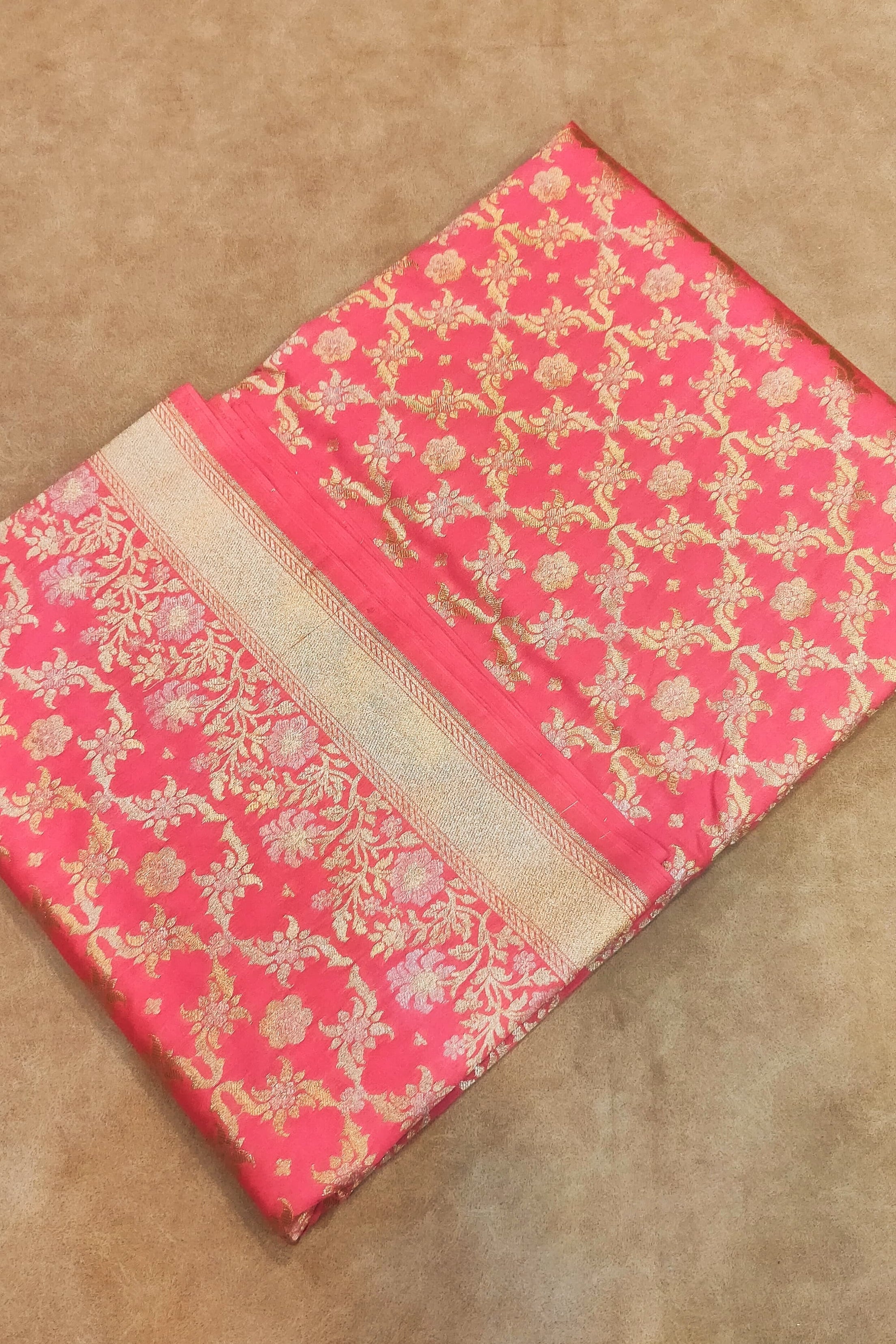 Pink fabric with gold patterns on a beige background