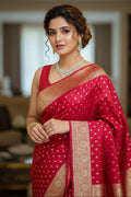 Woman in a red saree with gold patterns indoors