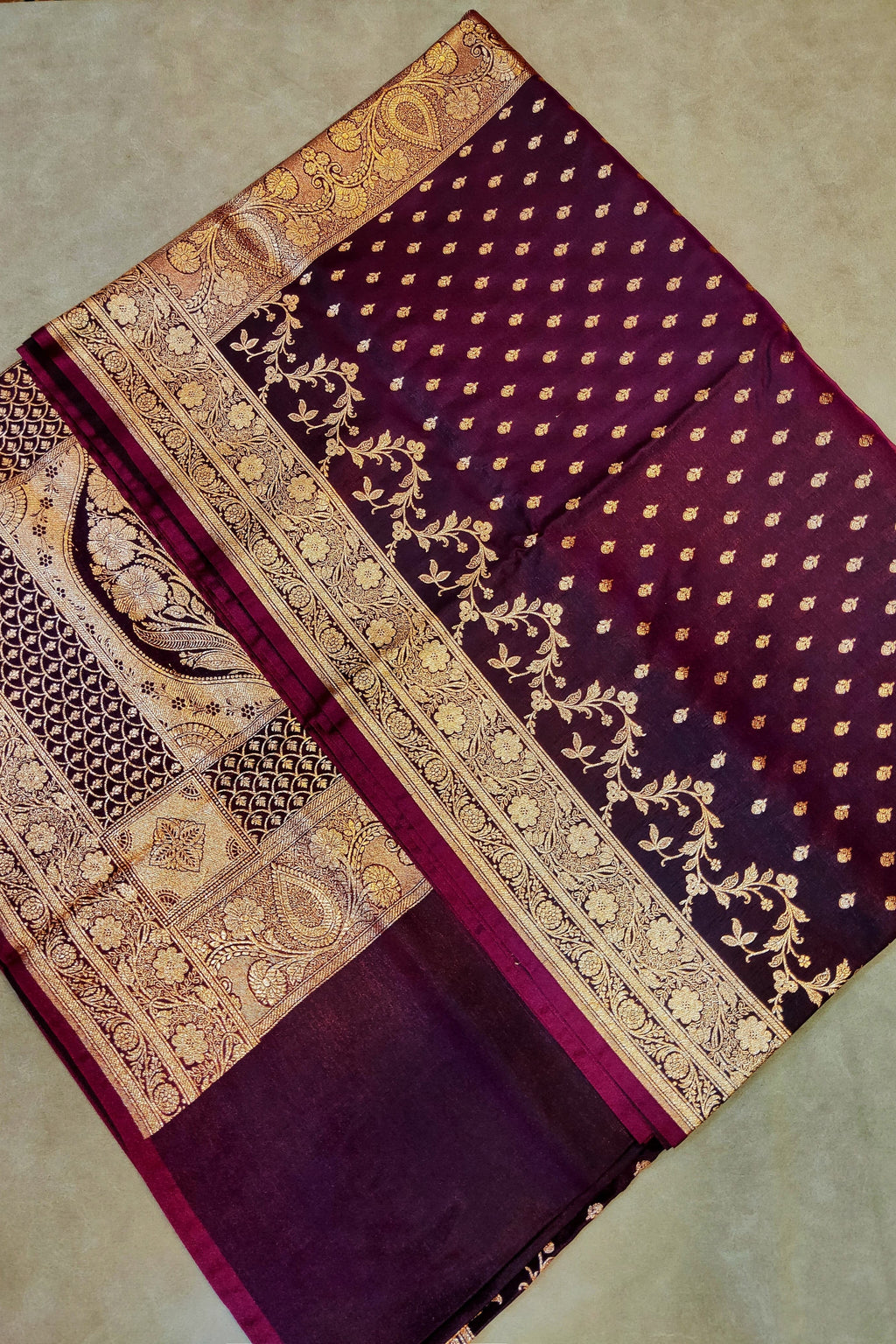 Purple fabric with gold embroidery on a beige background