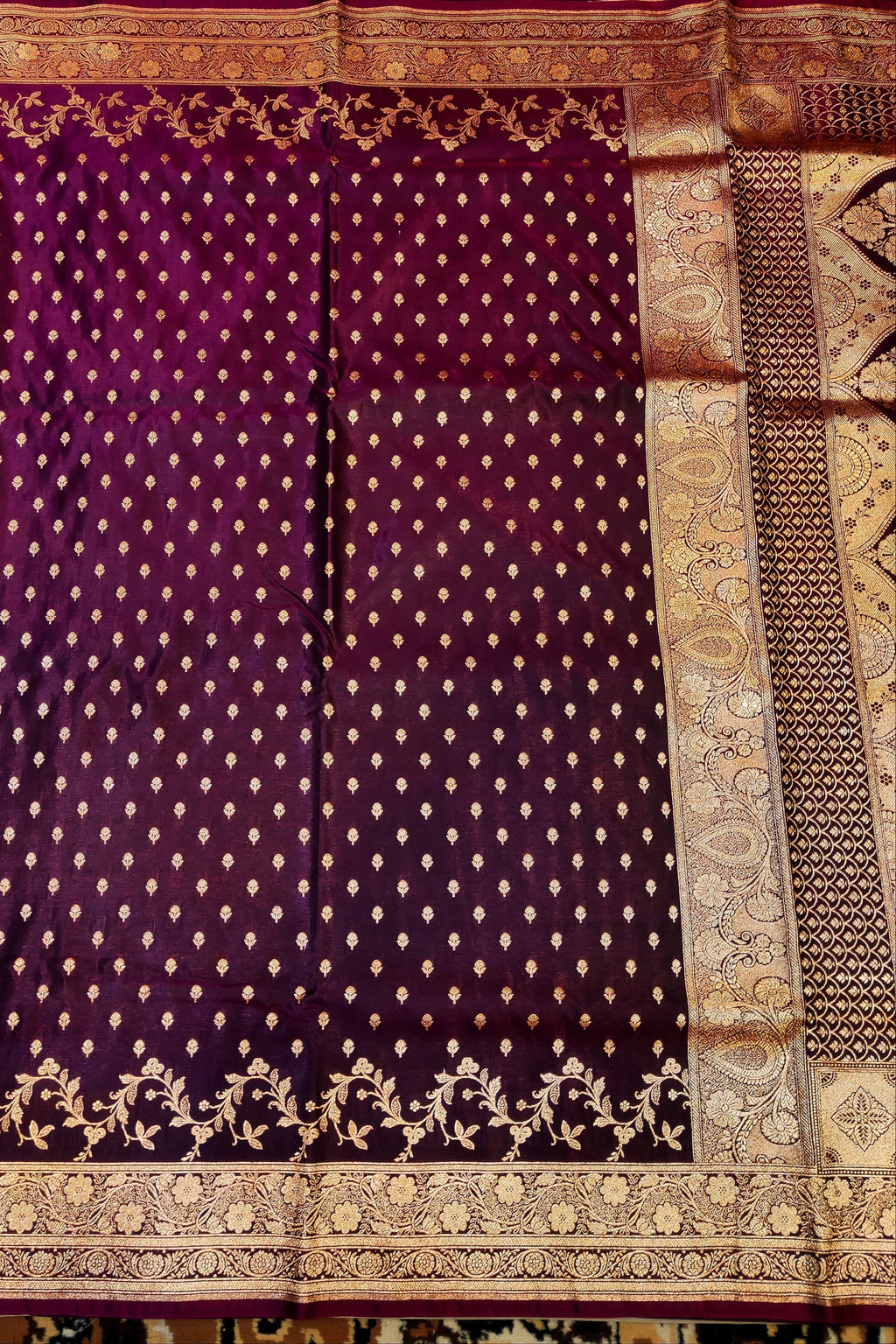 Purple saree with gold patterns on a textured background
