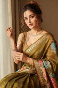 Woman in a traditional saree with floral patterns, wearing jewelry, against a neutral background.