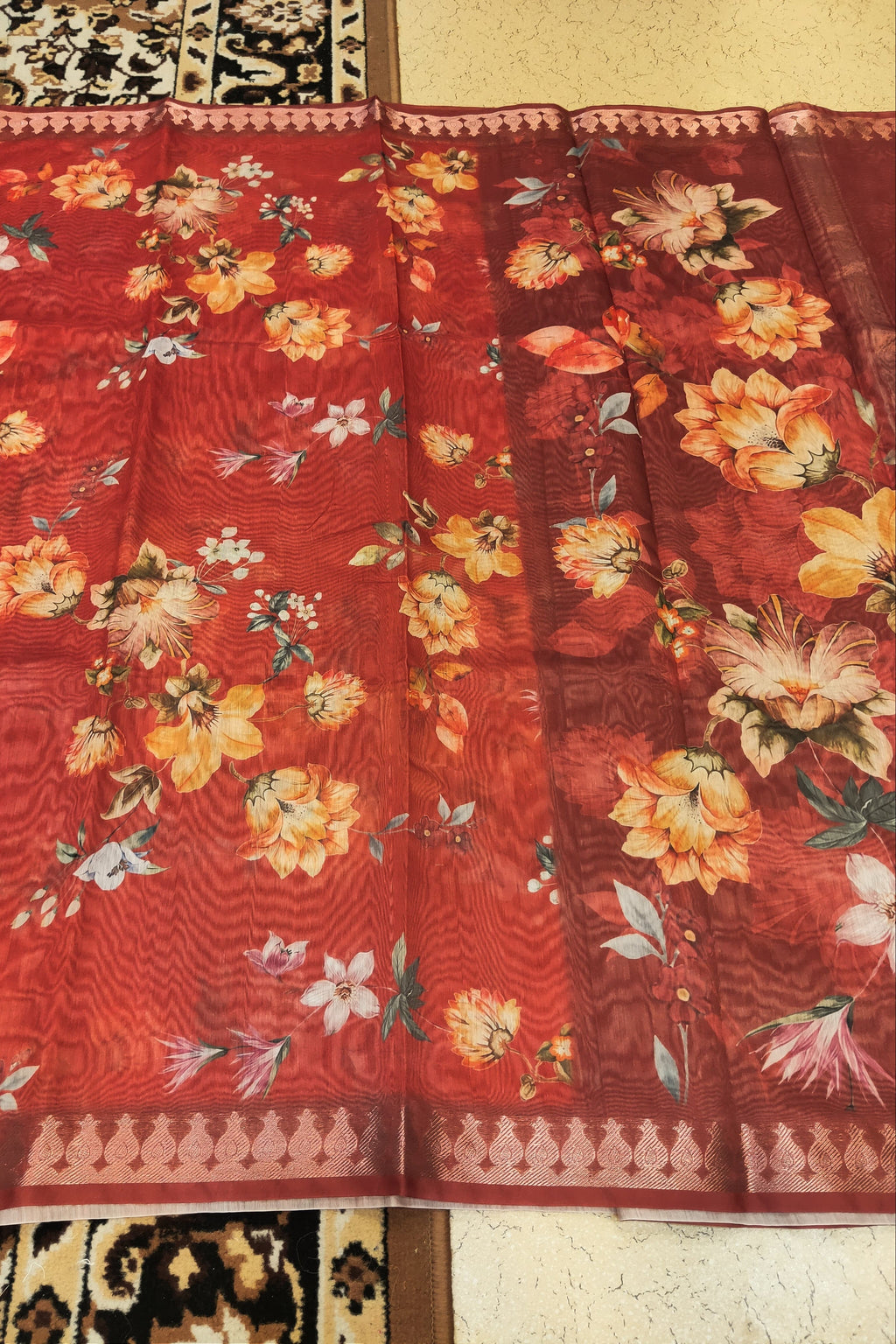 Red floral fabric with a pattern of flowers and leaves on a plain background
