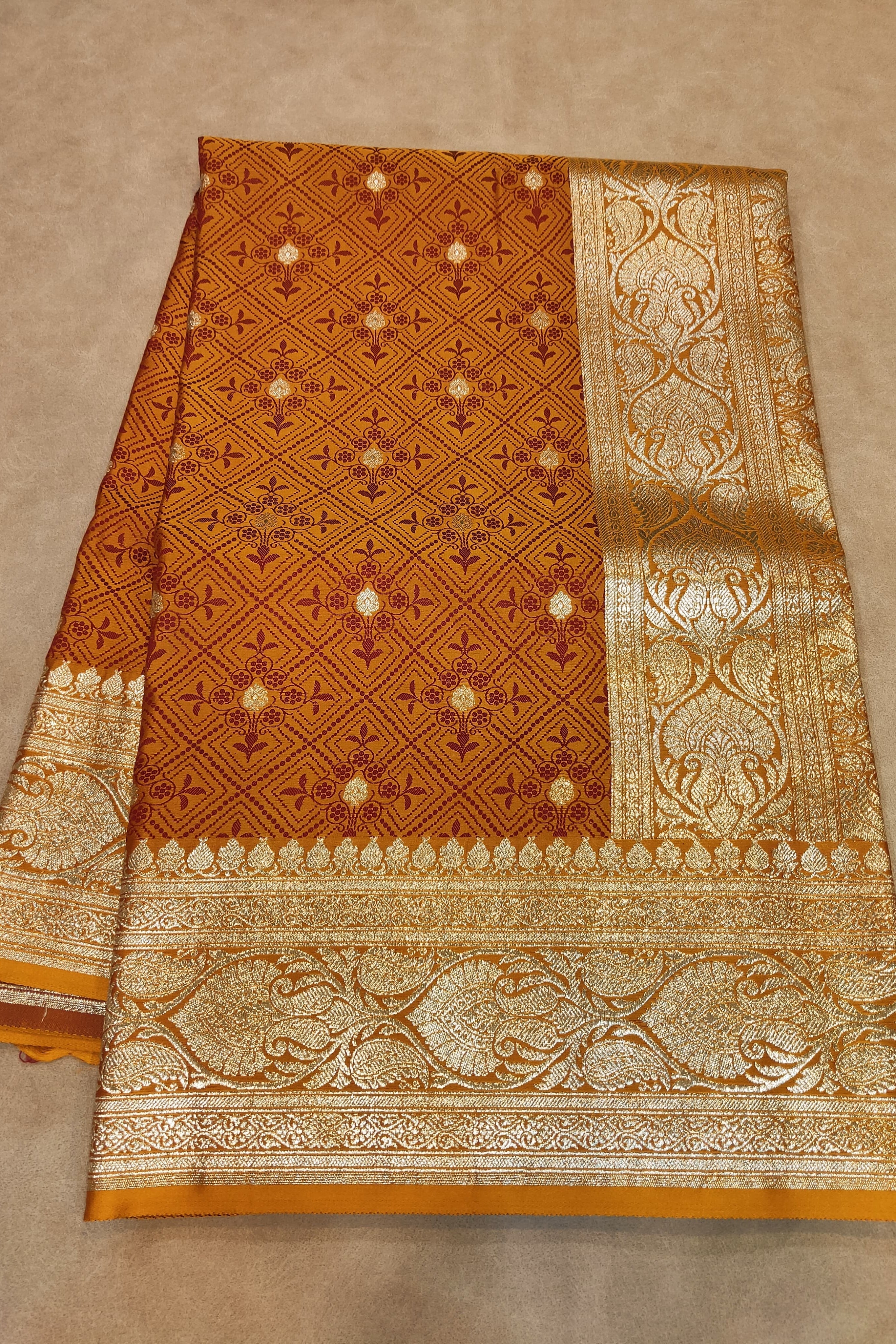 Brown and gold patterned fabric on a beige background
