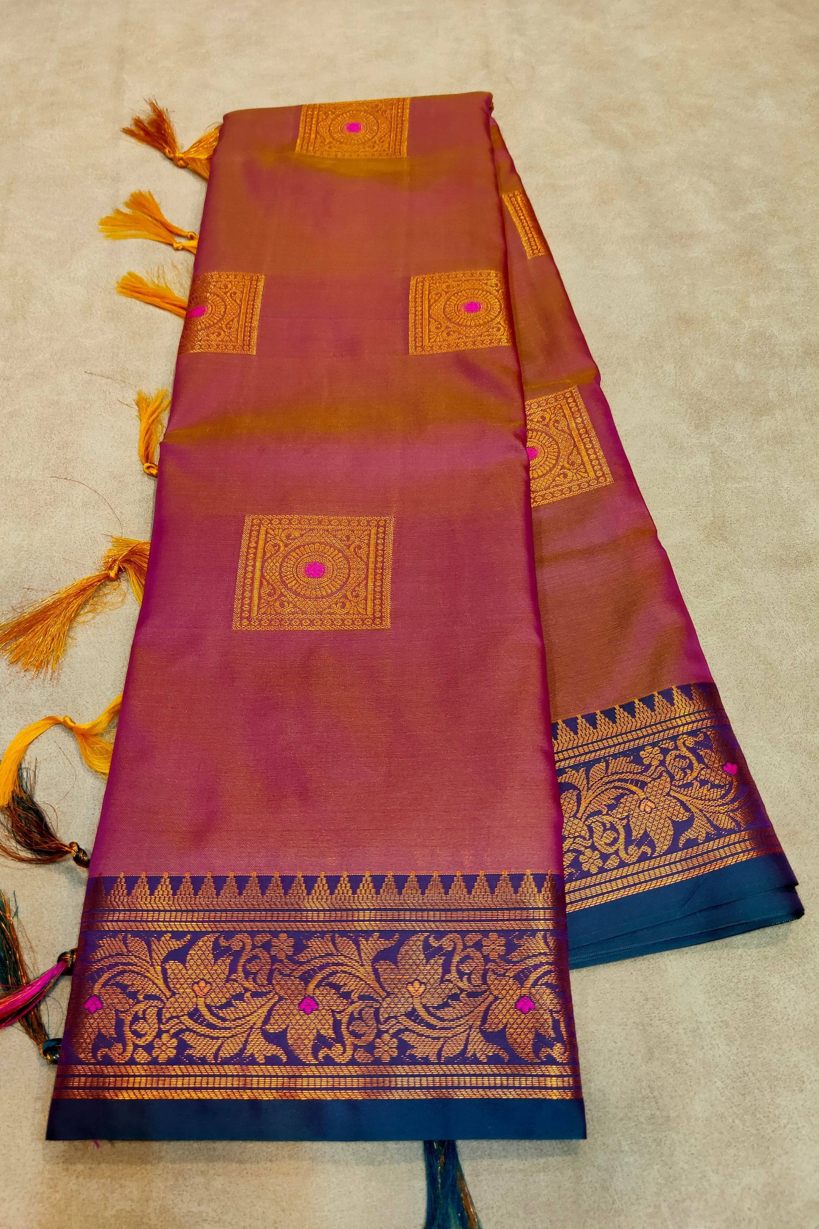 Woman wearing a green saree with intricate patterns indoors.