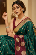 Woman wearing a green saree with gold patterns and a maroon blouse.
