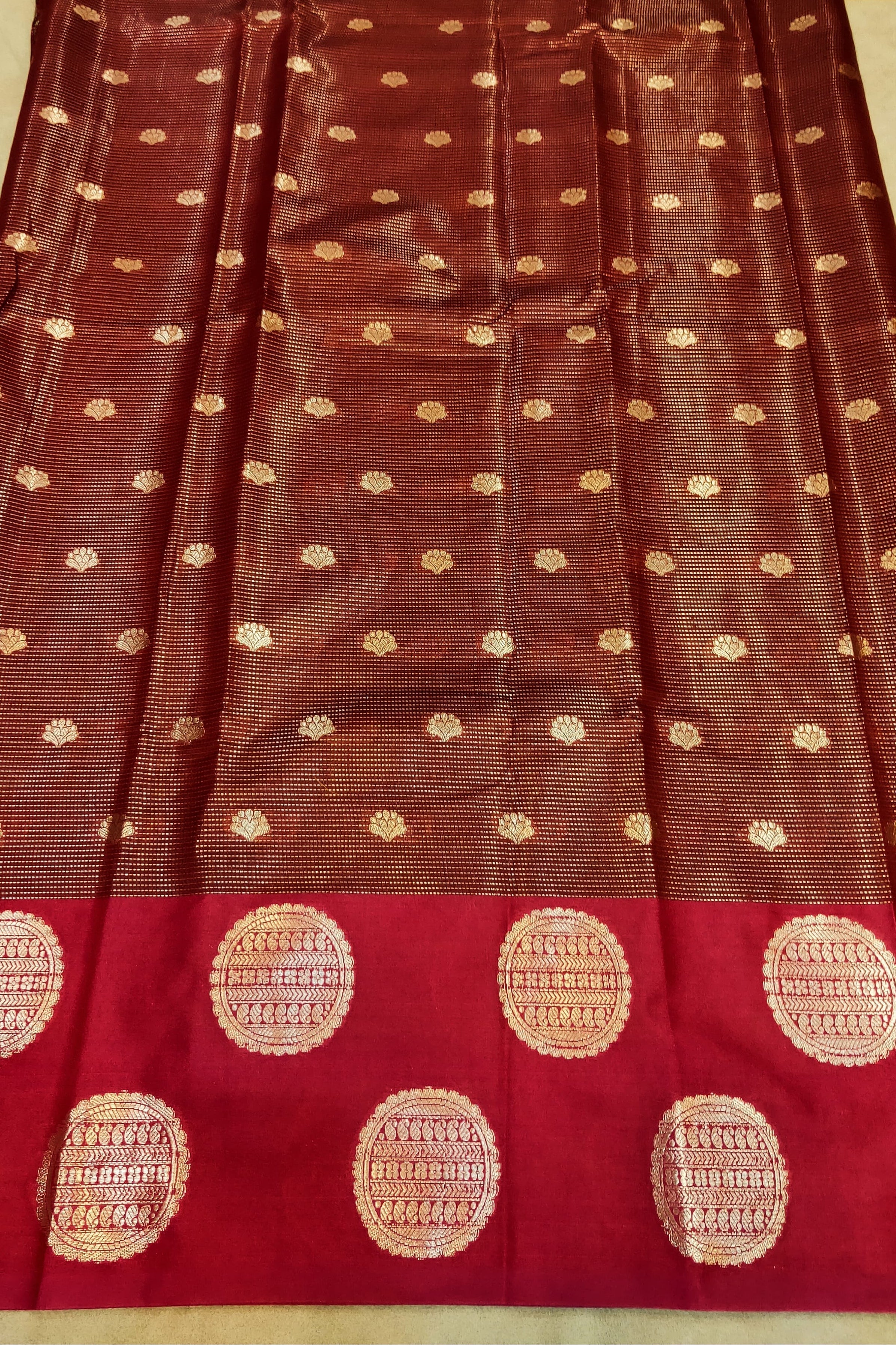 Brown saree with gold patterns on a red border