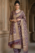 Woman wearing a traditional outfit with a patterned shawl in an architectural setting