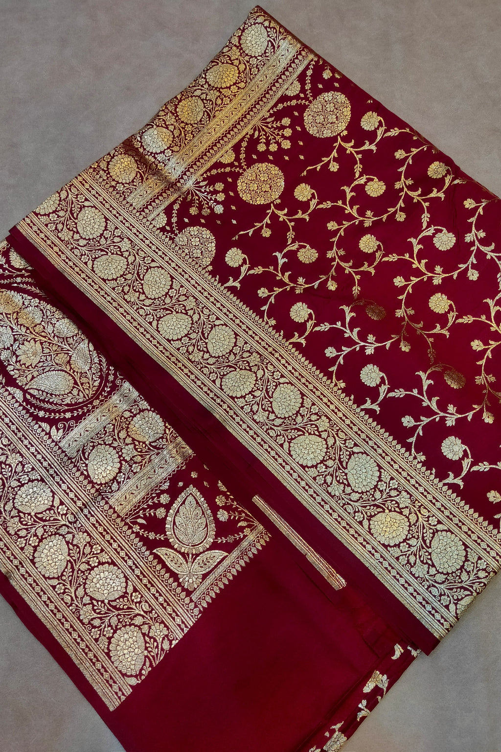 Red fabric with gold embroidery on a neutral background