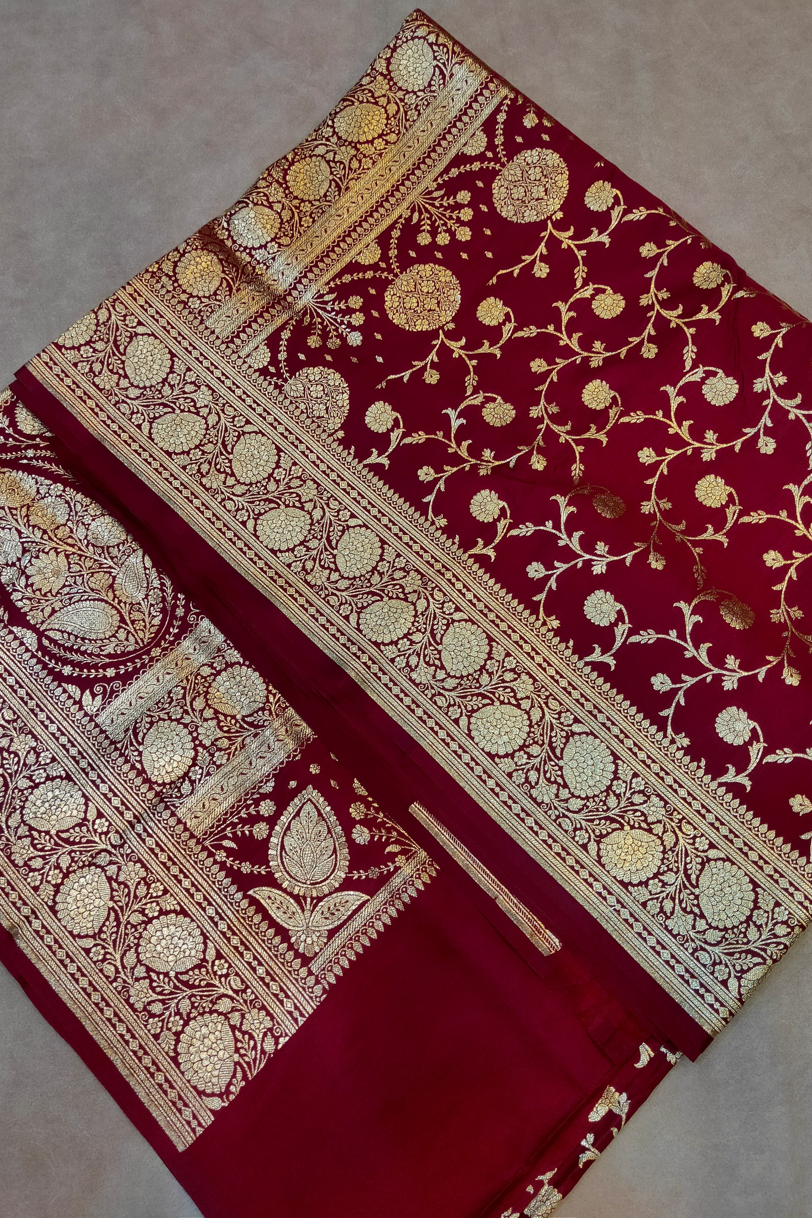 Red fabric with gold embroidery on a neutral background