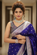 Woman in a blue saree with intricate patterns indoors