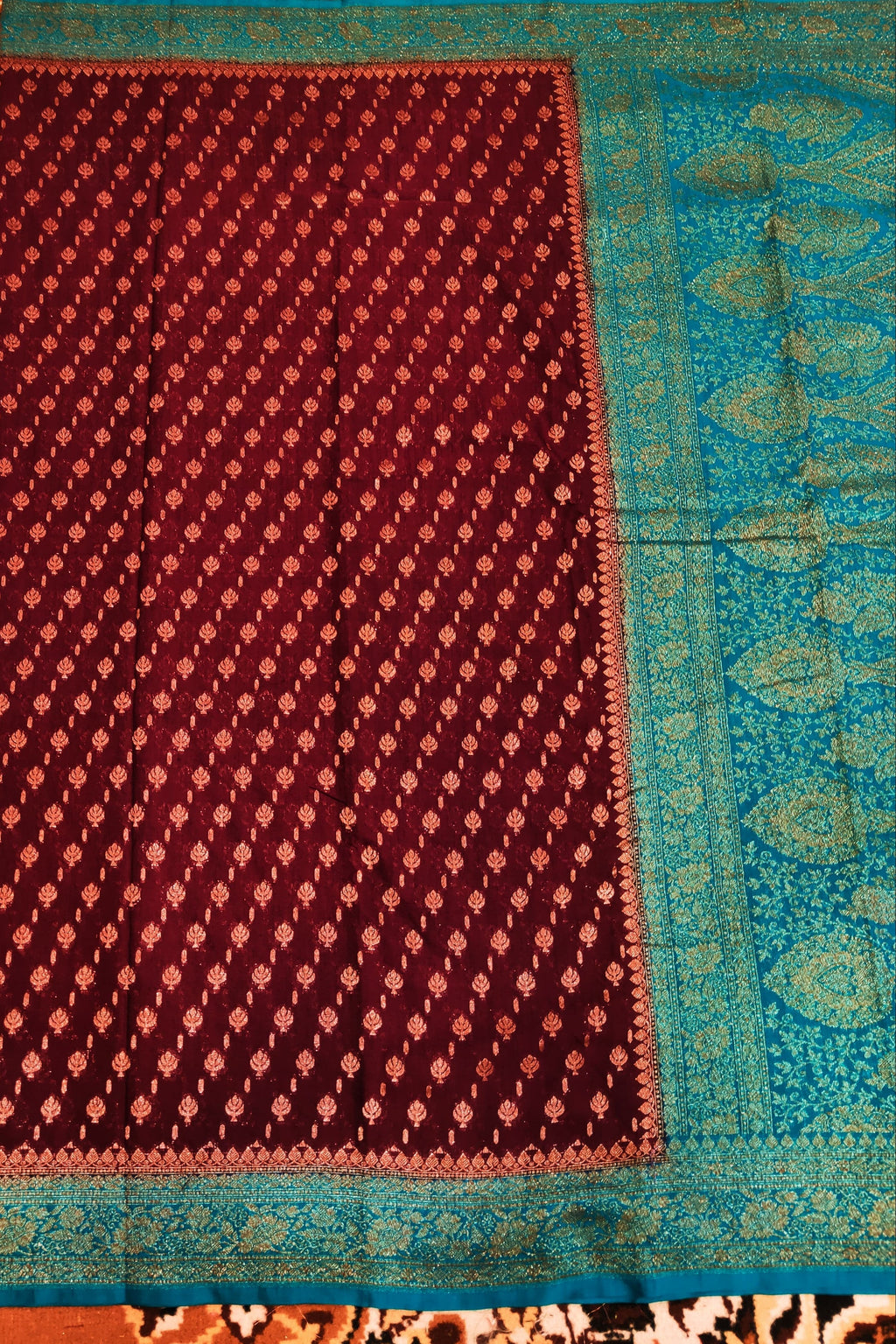 Traditional patterned fabric with a maroon and blue border on an intricate background