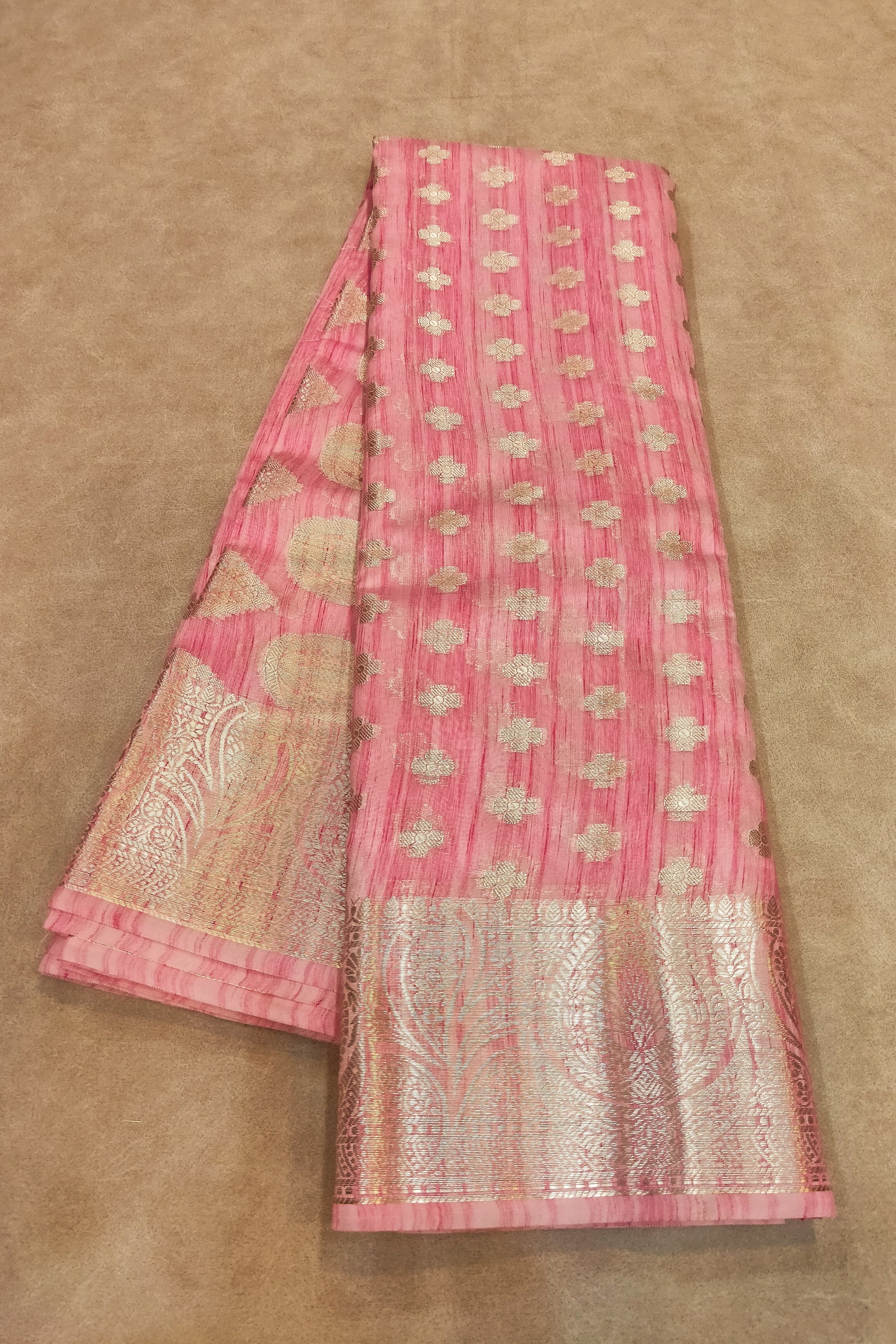 Pink saree with white patterns on a beige background