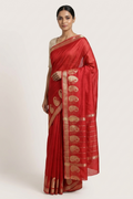 Woman wearing a red saree with gold patterns on a white background